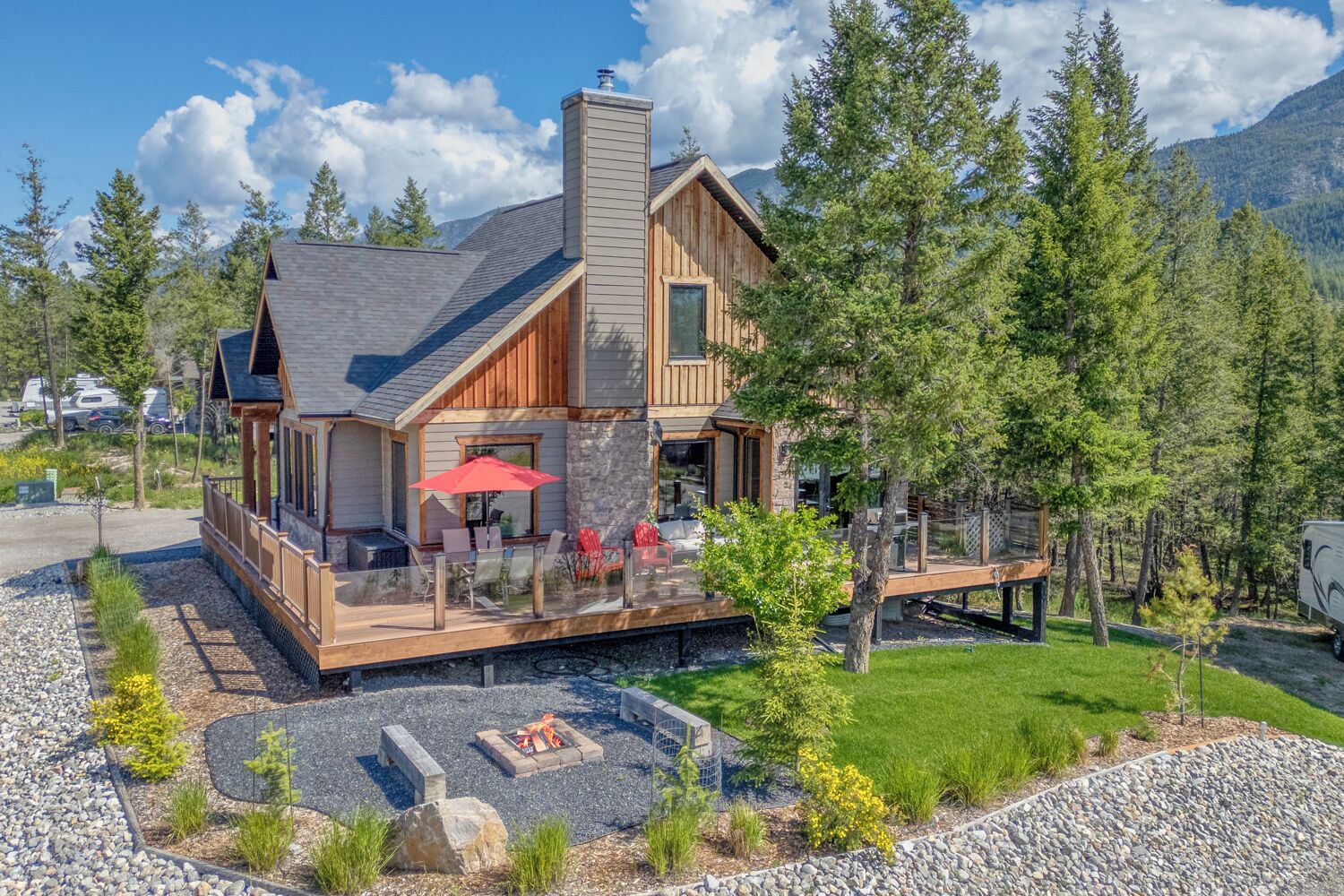 Une cabane dotée d’une terrasse, de meubles de jardin et d’un foyer extérieur.