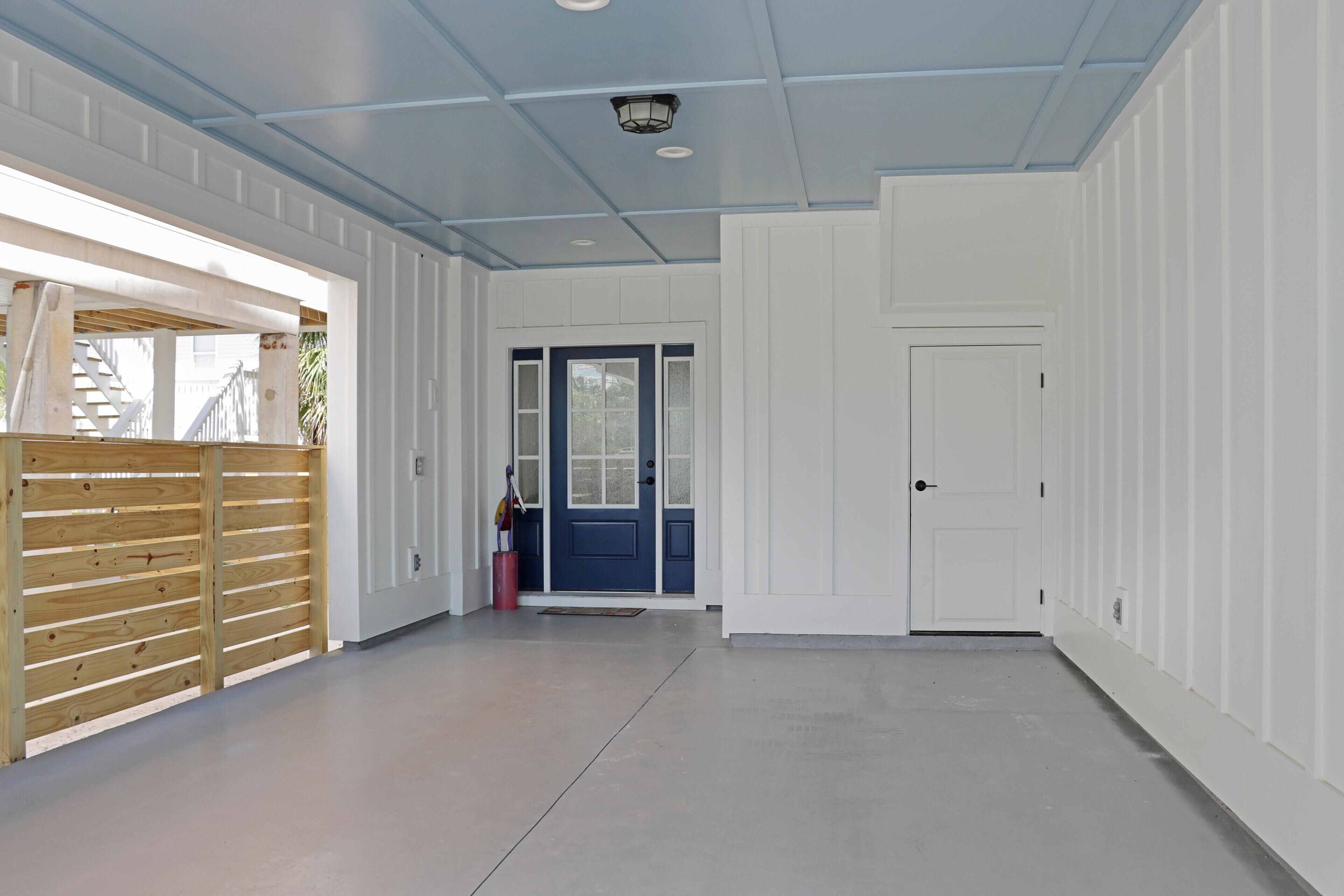 A spacious hallway with a wooden partition, a blue door, and a white door.