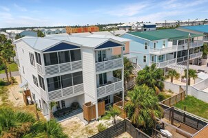 A multi-story residential building with a flat roof, large windows, and a balcony.