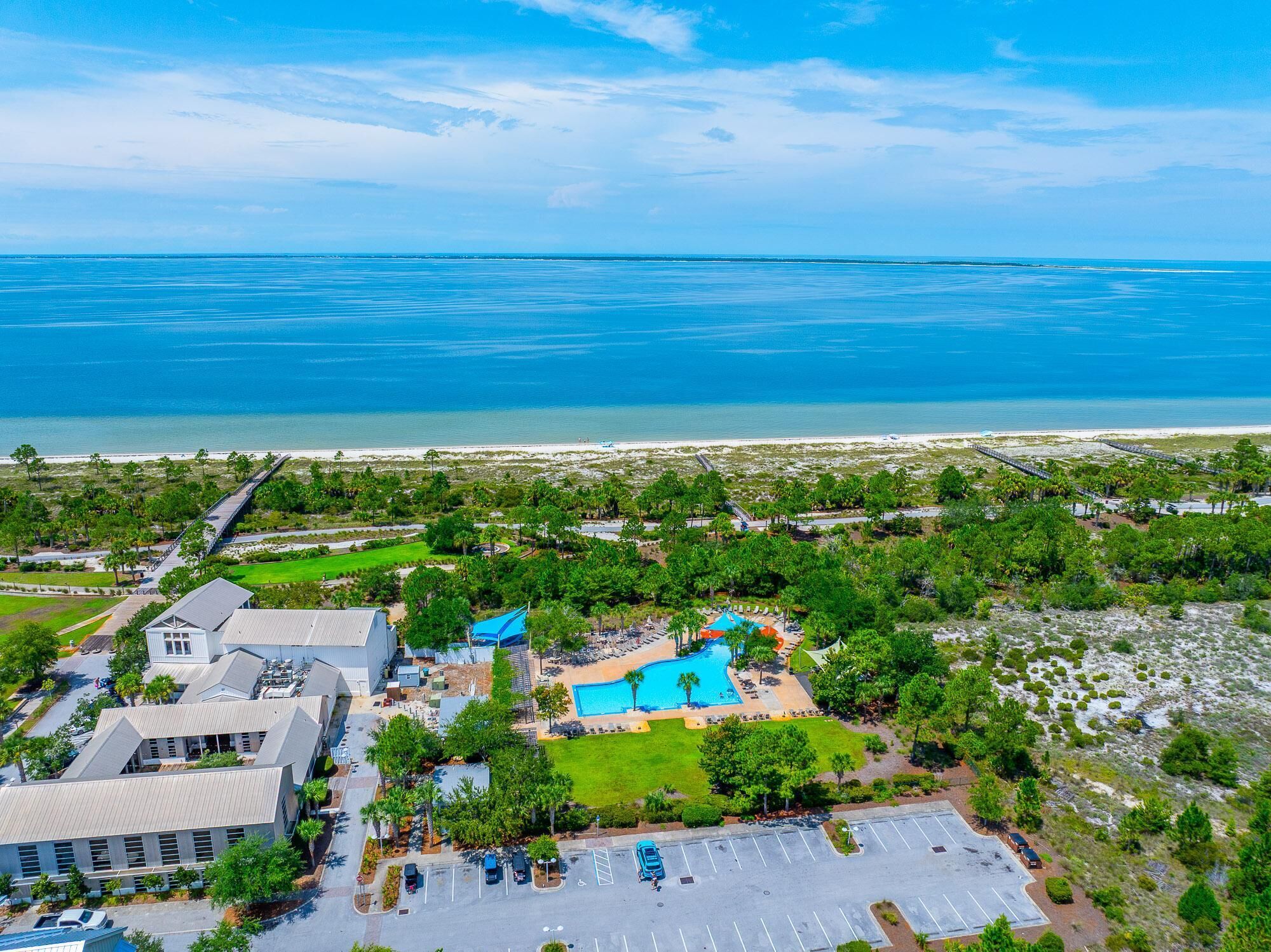 Ein Resort mit Schwimmbad, Parkplatz und Meerblick.