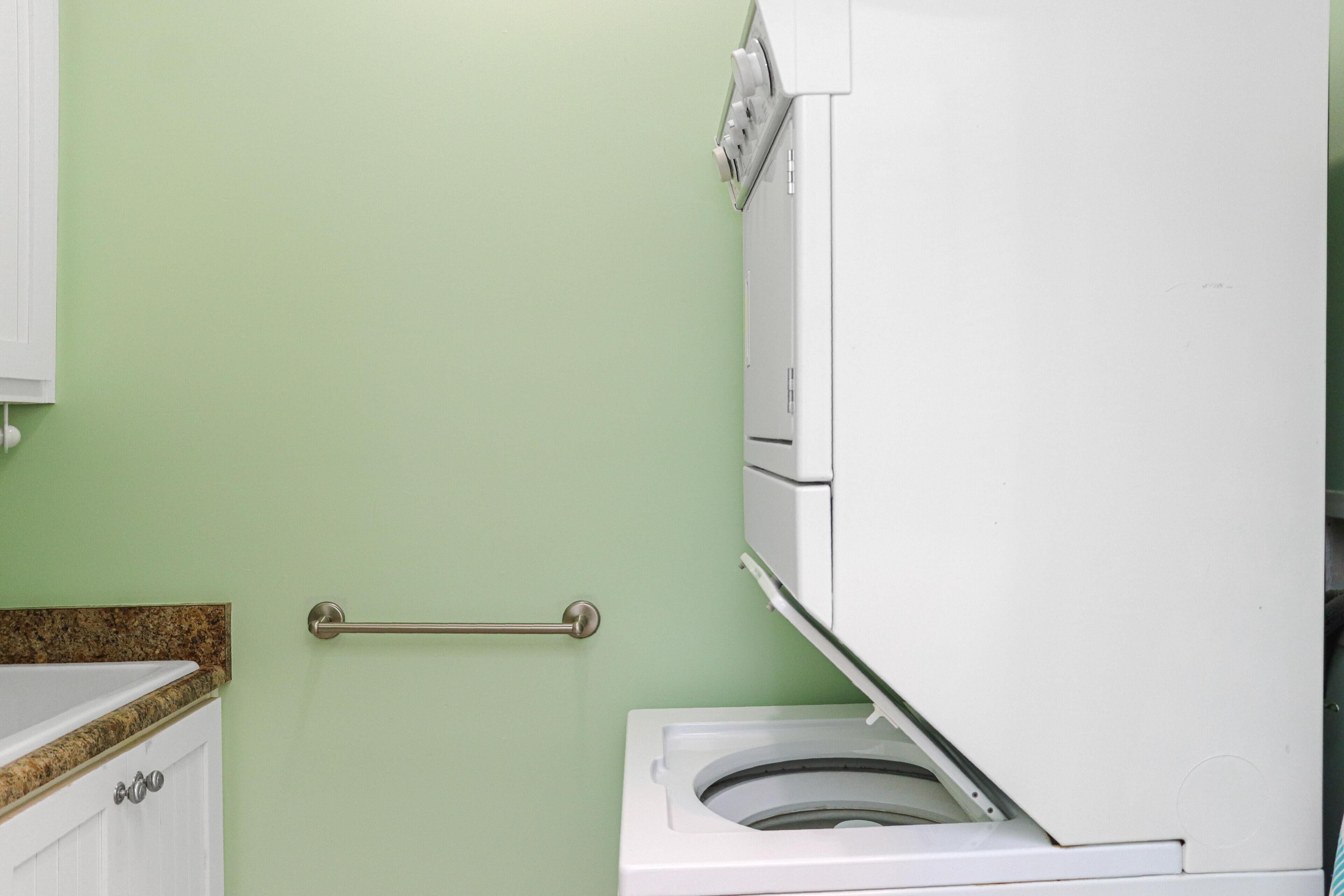 A bathroom with a white toilet, a towel rack, and a cabinet.