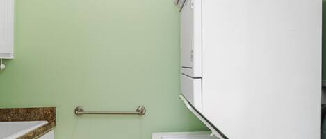 A bathroom with a white toilet, a towel rack, and a cabinet.