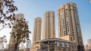 Un edificio residencial alto con varios balcones y un patio central.