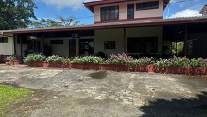 A two-story building with a flat roof and a covered porch. - Befox Adventure (La Fortuna)