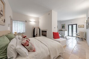 A bedroom with a bed, a desk, a chair, and a window.