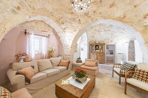 A cozy living room with a stone ceiling, a wooden coffee table, and a sofa.