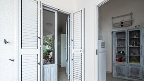Een kamer met een witte deur, een kleine koelkast en een kast met glazen deuren.