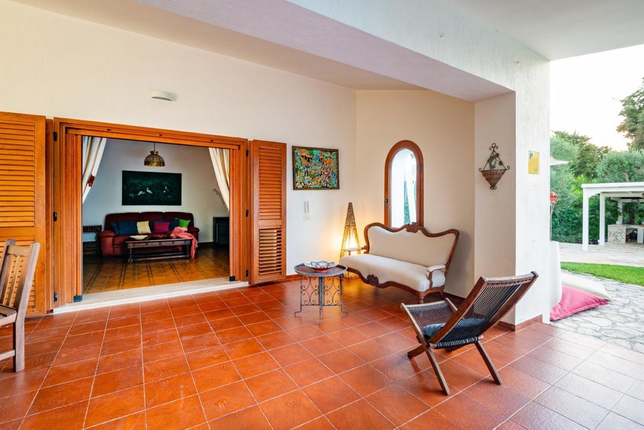 An open-plan living area with a sofa, a chair, a table, and a lamp.