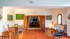 Una habitación amplia con comedor, un sofá y una mesa con sillas.
