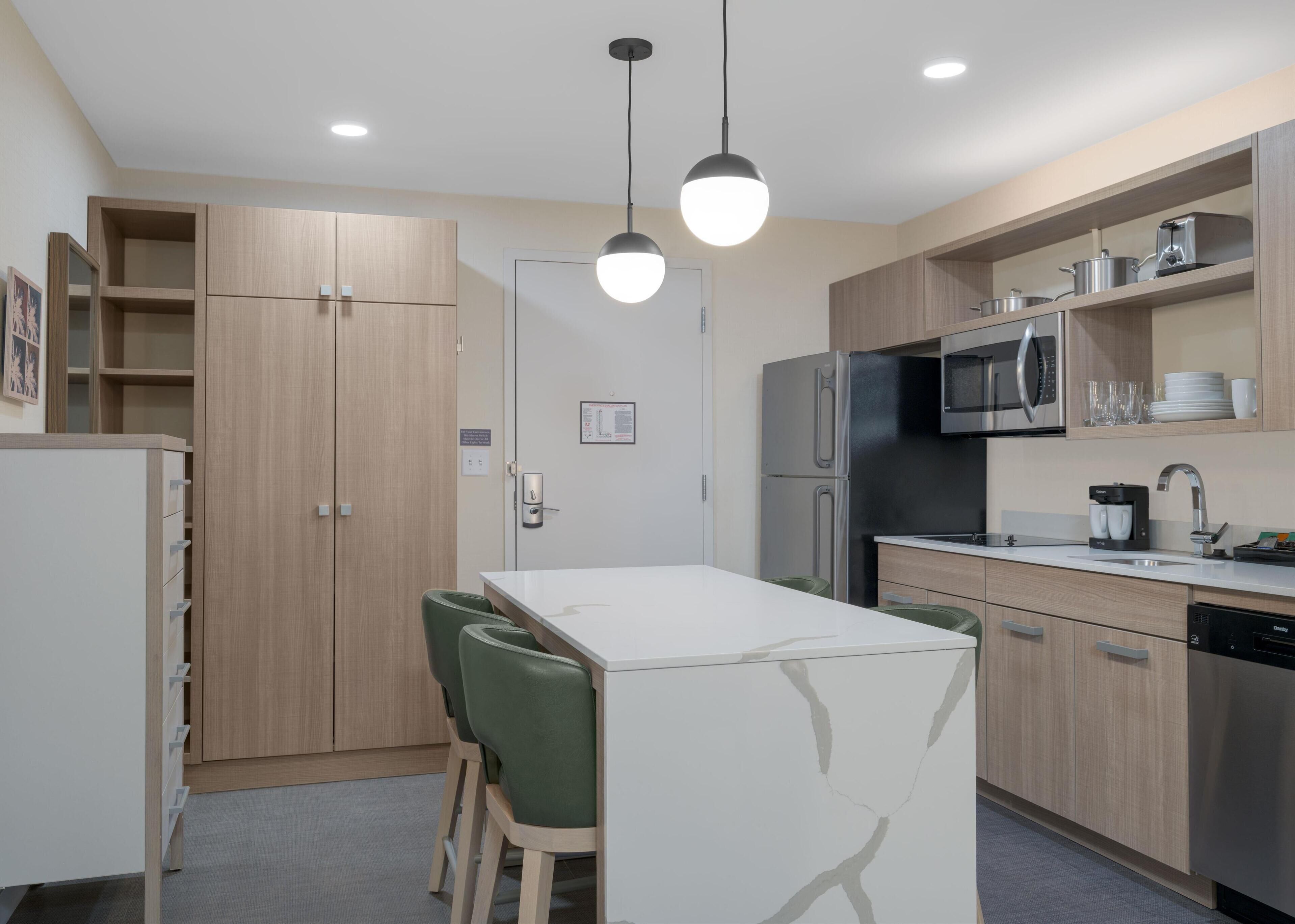 Une cuisine moderne avec une table à manger, des chaises et un réfrigérateur.