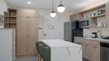 Une cuisine moderne avec une table à manger, des chaises et un réfrigérateur.