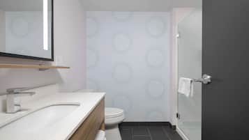 Un baño moderno con lavamanos independiente, inodoro y cabina de ducha de vidrio.