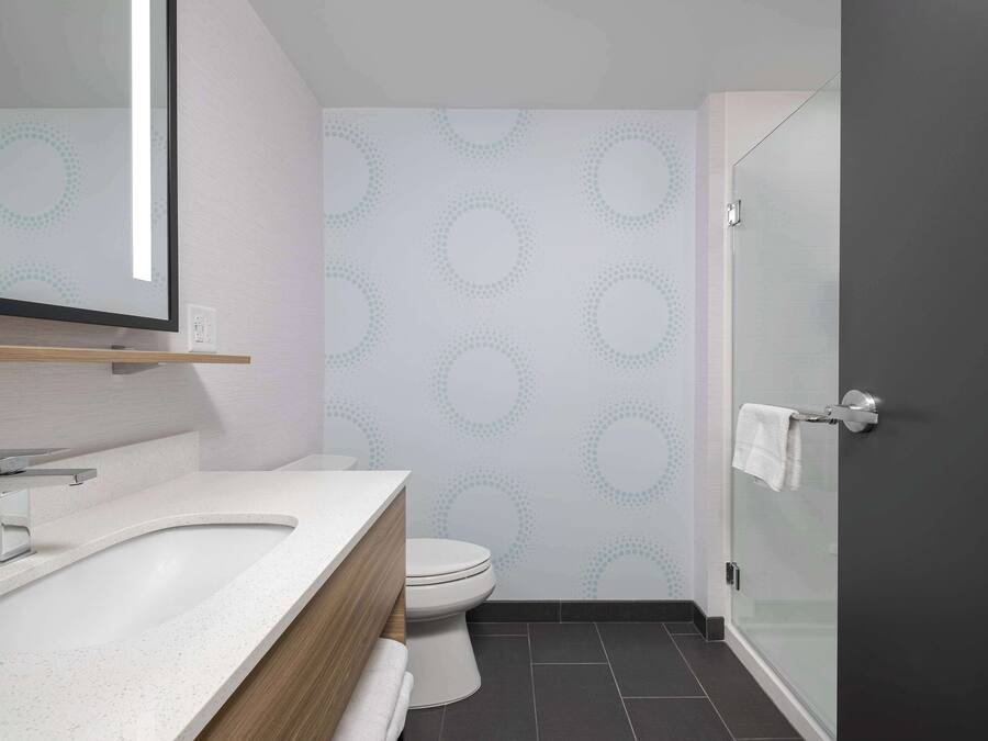 Un baño moderno con lavamanos independiente, inodoro y cabina de ducha de vidrio.
