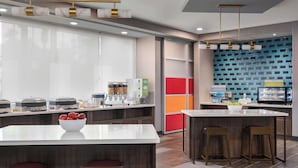 Una cocina moderna con una isla central, taburetes de bar y un salpicadero colorido.