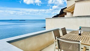Una terraza con una mesa y sillas con vistas al mar.