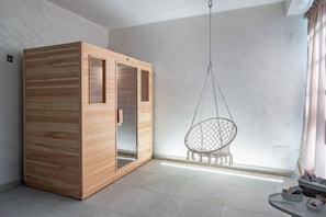 Une pièce avec une armoire en bois, un fauteuil suspendu et un sol carrelé.