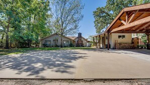 A two-story house with a covered porch, a stone fireplace, and a well-maintained lawn.