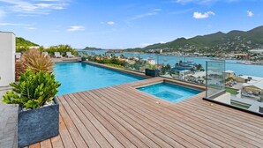 Una piscina en la azotea con vistas a un puerto deportivo y al paisaje urbano.