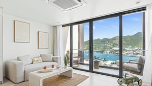 A modern living room with a large window, a sofa, a coffee table, and a toy car. - B246 - Breathtaking Lagoon View with Balcony (Sint Maarten)
