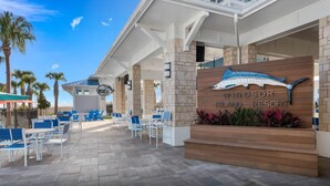 The exterior of Windsor Island Resort with a signboard, outdoor seating area, and palm trees. - Brand New Windsor Island 10BR Mansion/Pool/Spa (Davenport)