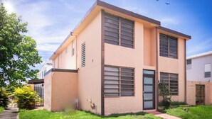 A two-story building with a flat roof, large windows, and a small front porch. - 3BR Apartment w/ HDTV, 5 mins from Beach, pets OK.  (Río Grande)