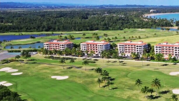 A golf course with a hotel complex in the background. - 3BR Apartment w/ HDTV, 5 mins from Beach, pets OK.  (Río Grande)
