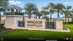 The entry sign of Windsor Island Resort with a clear sky and palm trees in the background.