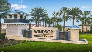 The entry sign of Windsor Island Resort with a clear sky and palm trees in the background. - Amazing Windsor Island 7BR/Pool/Spa/closeTo Disney (Davenport)