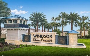 El cartel de entrada del Resort Windsor Island, con un cielo despejado y palmeras al fondo.
