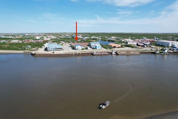 A coastal town with a marina, houses, and a large body of water. - River House Hotel (Bethel)
