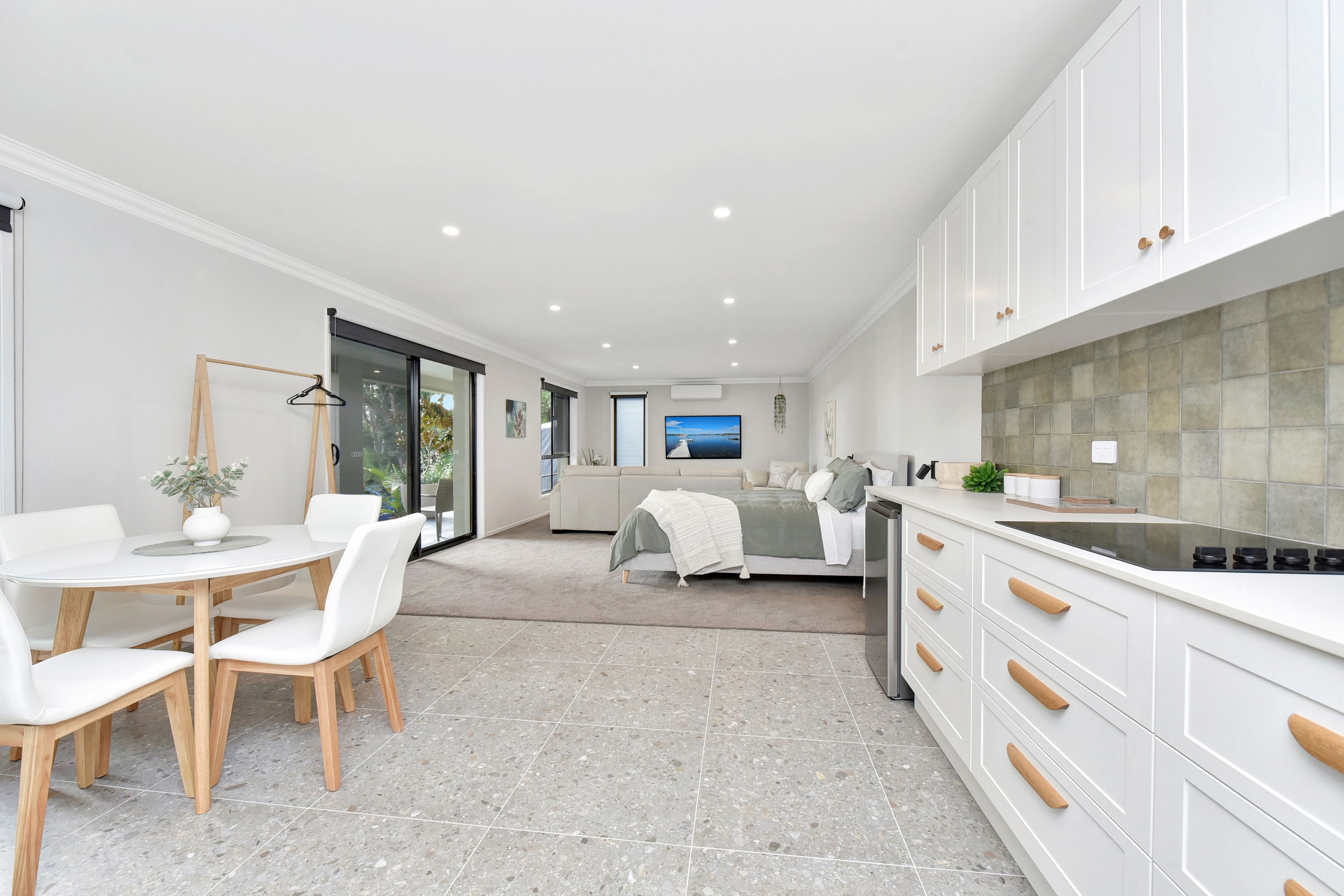 Een modern interieur met een eethoek, keuken en een slaapkamer met uitzicht.