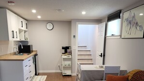 A modern apartment with a kitchen, living room, and a staircase.
