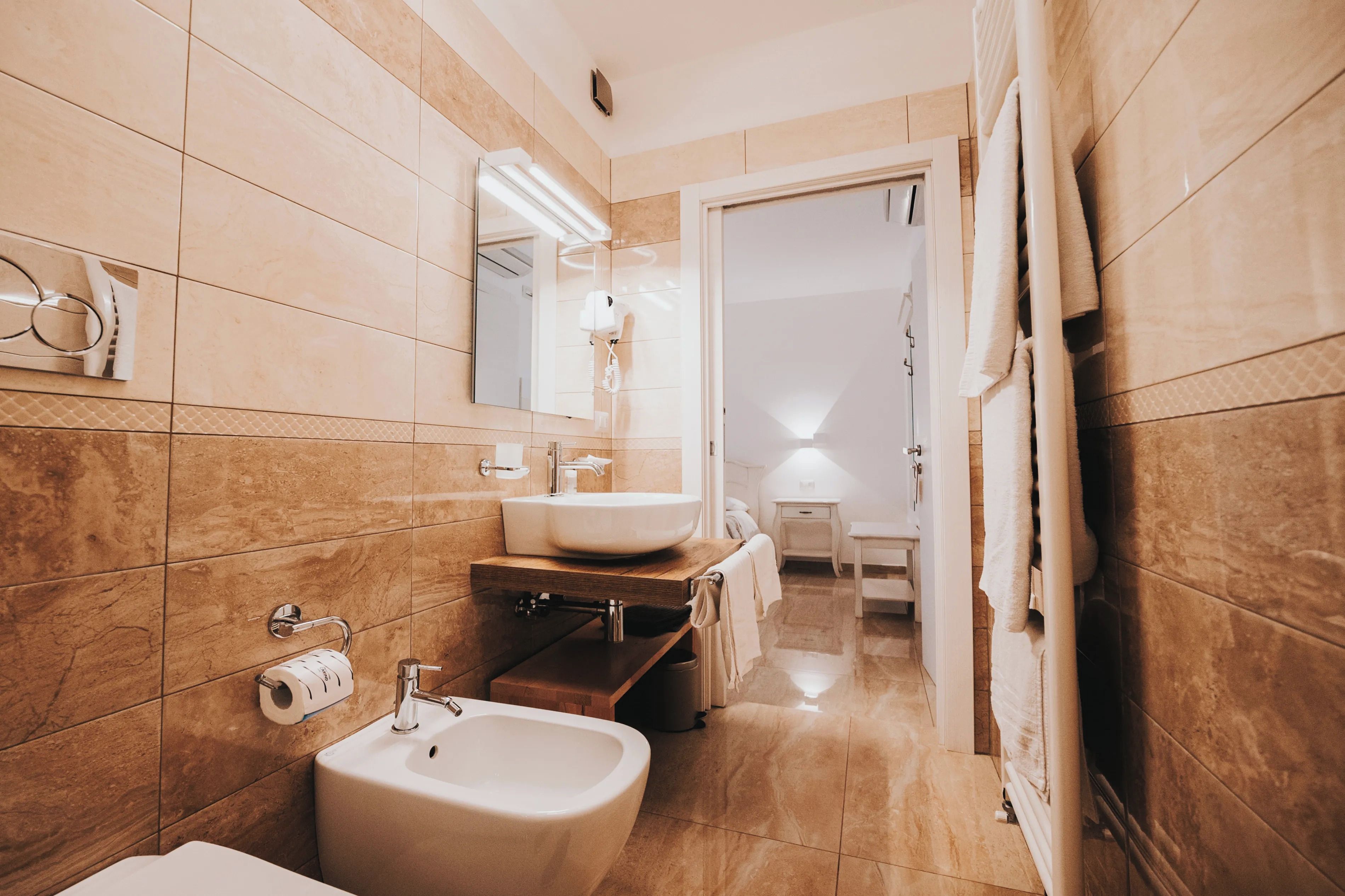 Un baño moderno con un lavamanos grande, espejo y perchero.