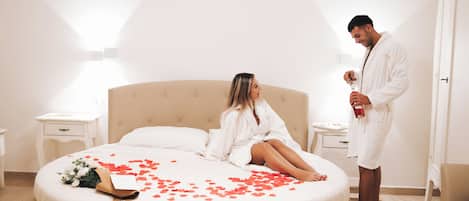 A room with a bed, a nightstand, a bedside table, and a door.
