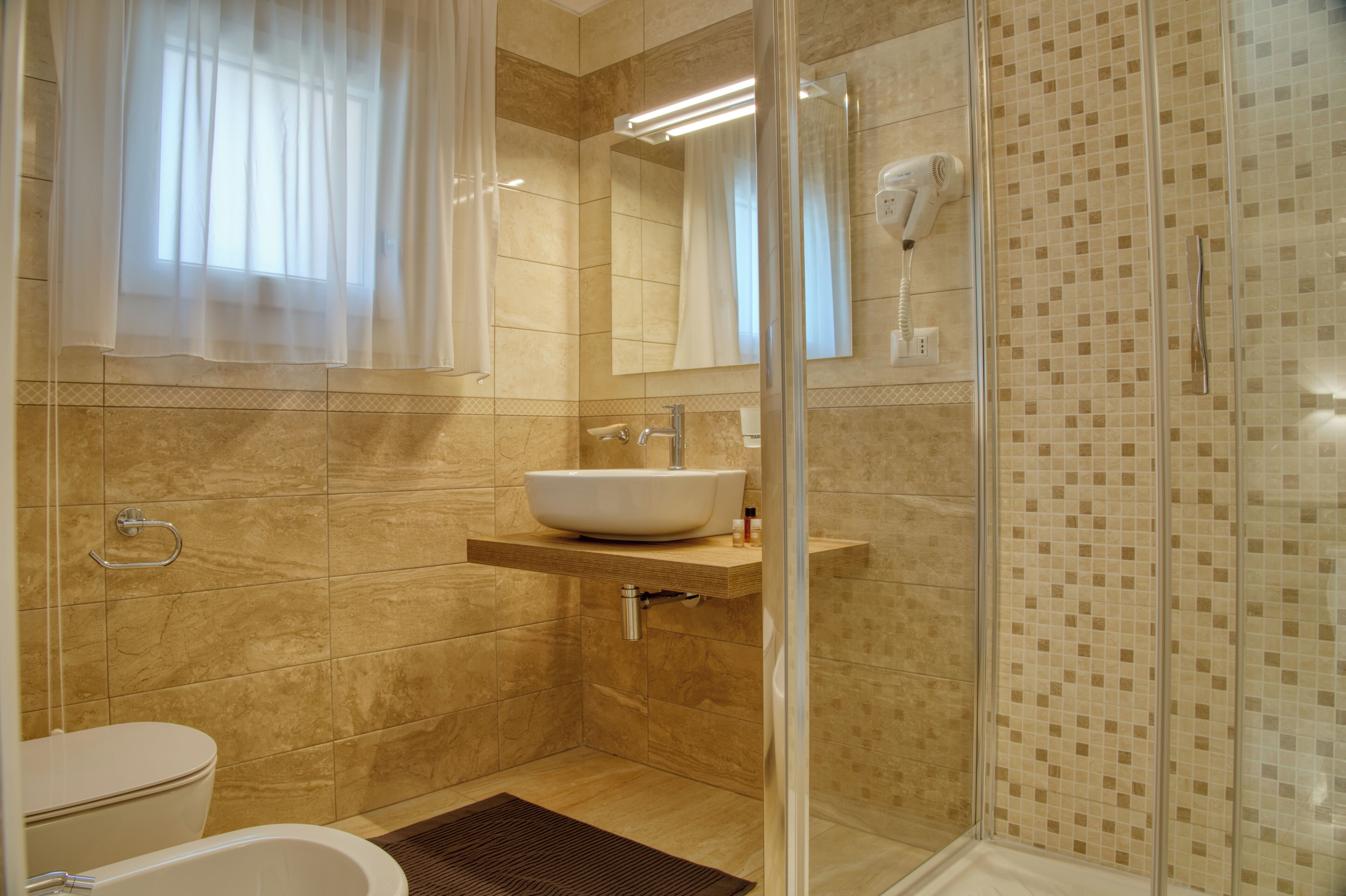 A modern bathroom with a glass shower enclosure, a built-in sink, and a toilet.