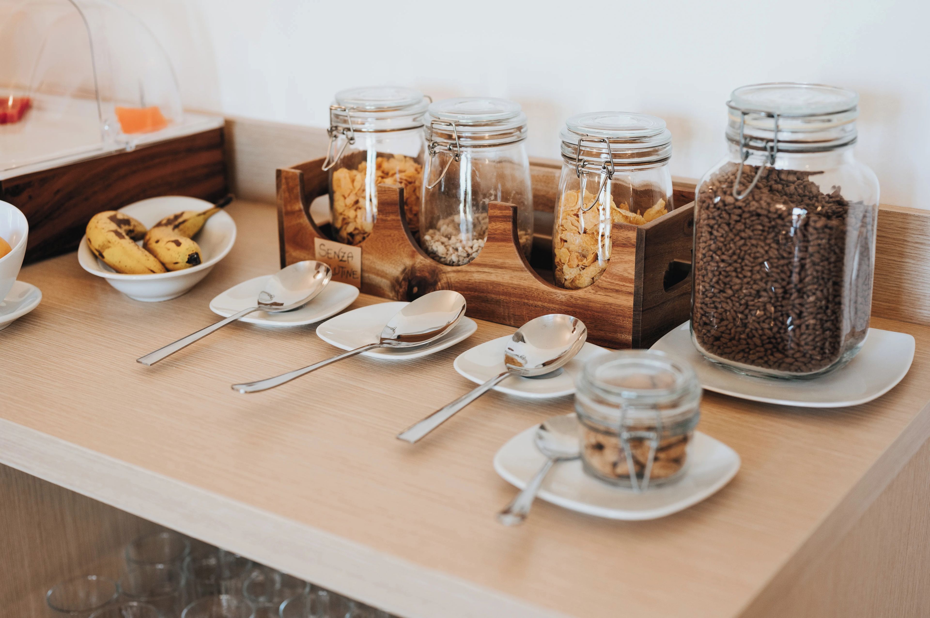 A breakfast buffet setup with various food items and utensils.