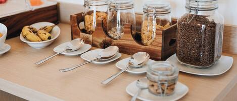 A breakfast buffet setup with various food items and utensils.