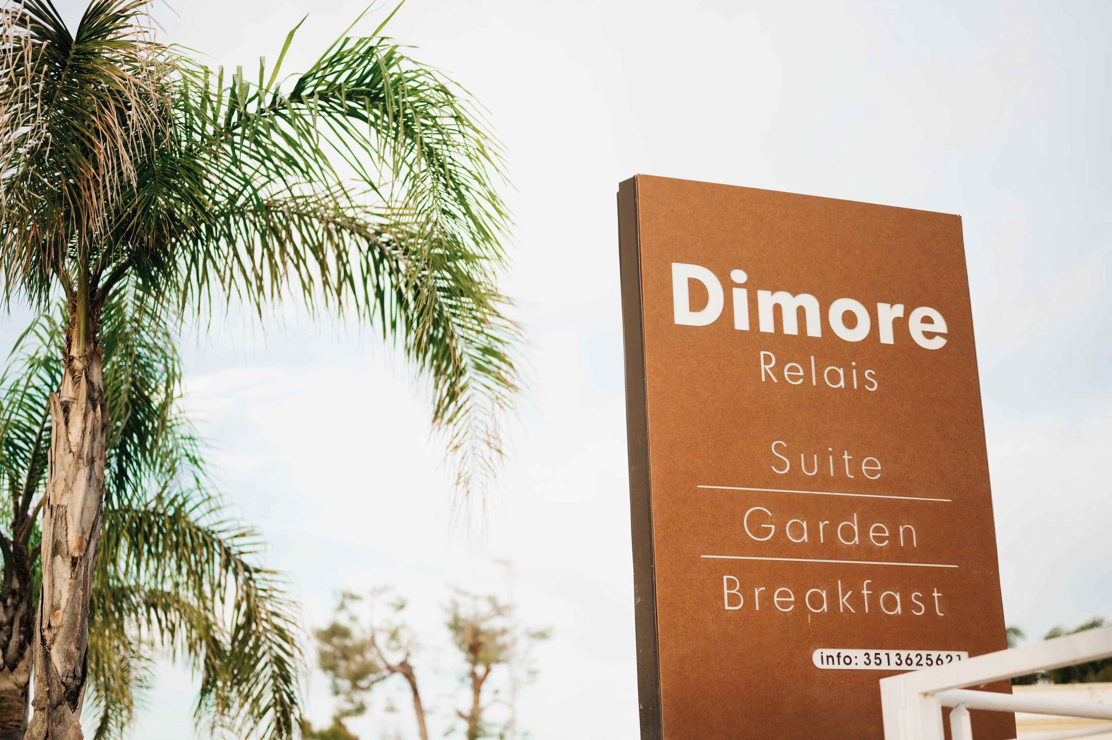 A sign for 'Dimore Relais Suite Garden Breakfast' with a contact number.