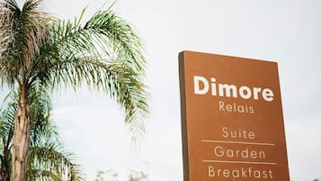 A sign for 'Dimore Relais Suite Garden Breakfast' with a contact number.