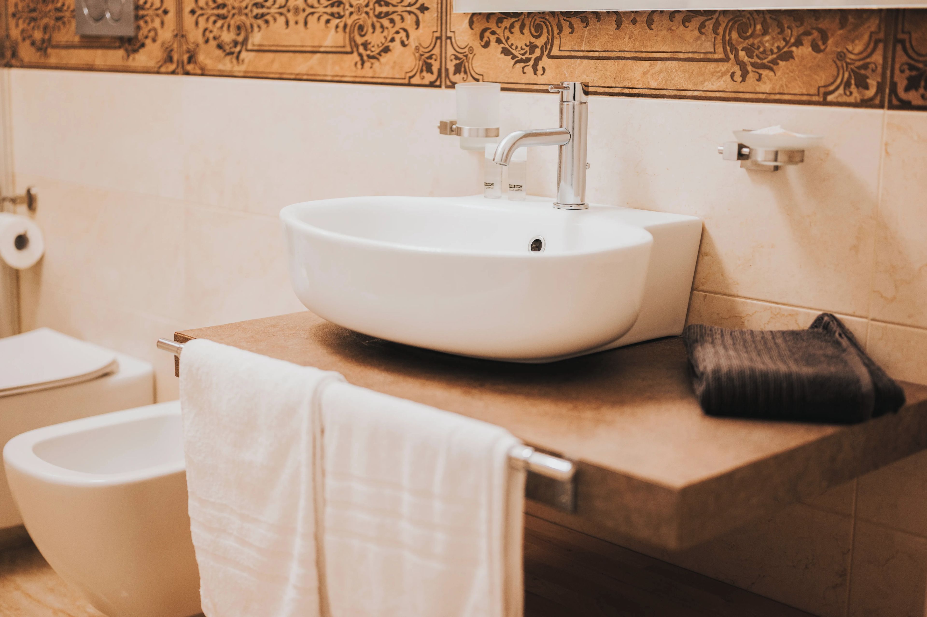 A bathroom with a white sink, a towel, and a bidet.