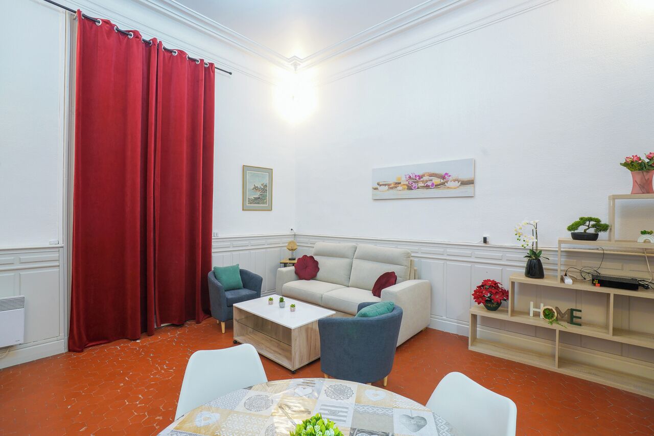 Een woonkamer met een bank, stoelen, een salontafel en een tv-meubel met decoratieve objecten.