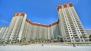 Um hotel alto com várias varandas e localização à beira-mar.