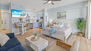 Uma sala de estar moderna com um sofá, mesa de centro e uma área de jantar com cadeiras.