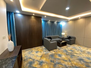 A modern living room with a sofa set, a coffee table, and a lamp. - فندق فصل الصيف امان المنسك (Abha)