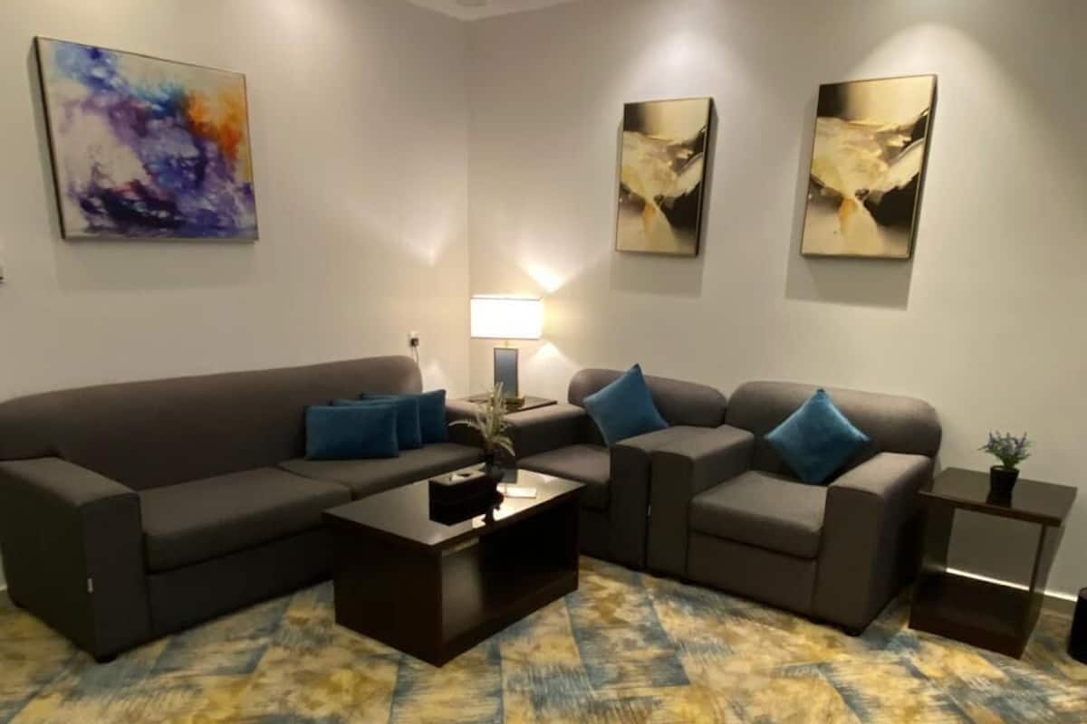 Uma sala de estar moderna com um sofá seccional, uma mesa de centro e obras de arte nas paredes.