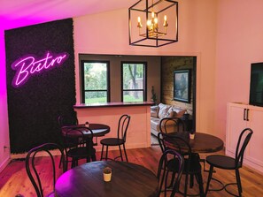 A cozy room with a neon sign reading "Bistro," wooden furniture, a chandelier, and a view of the outdoors. - Sprawling 3-bedroom house in delightful Scroggins with WiFi, AC and lakeview (Scroggins)