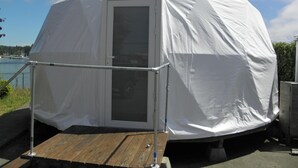 Una tenda a forma di cupola con un'apertura e una piccola piattaforma di legno.