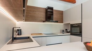 Una cocina moderna con horno integrado, cafetera y un mueble de madera.