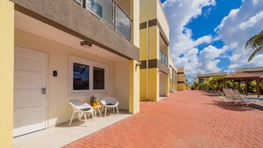 A modern building with a brick pathway, outdoor seating, and a pool area.