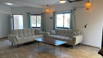 Ático de diseño, 2 habitaciones | Zona de estar | Smart TV de 55 pulgadas con canales digitales, servicios de streaming